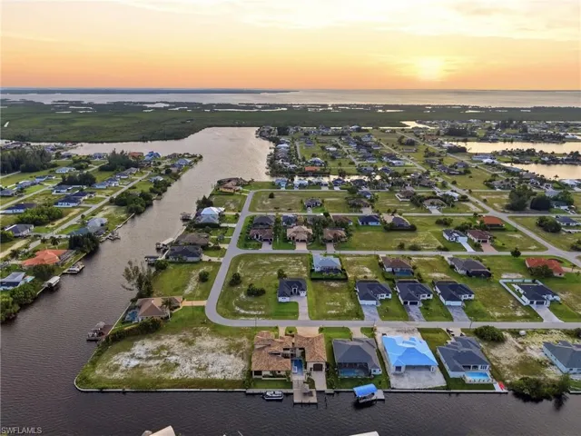 Aerial panorama of a residential canal-front community with numerous properties featuring private boat docks