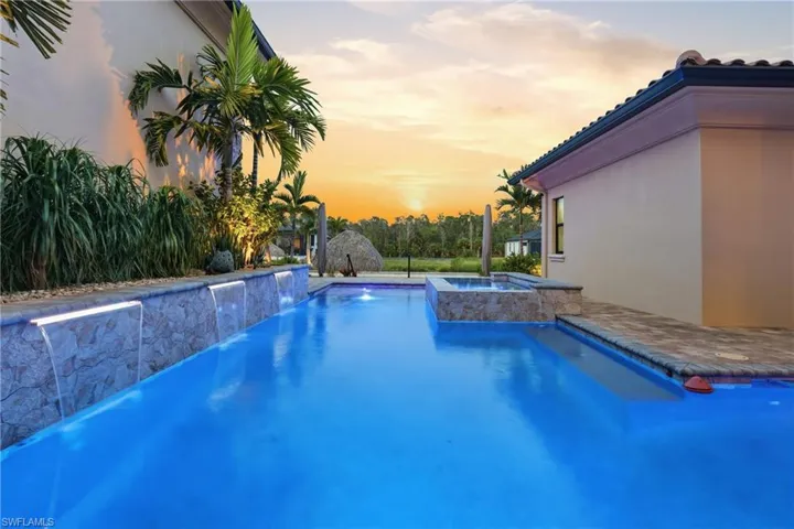 Custom swimming pool featuring multiple waterfall cascades and integrated spa