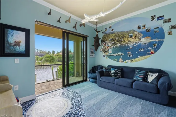 Play room. Sliding glass doors open to a screened porch, offering waterfront views