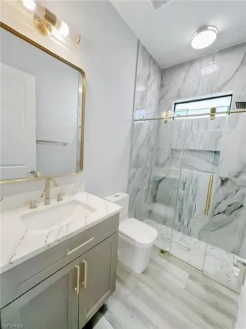 Bathroom with a marble finish shower and vanity