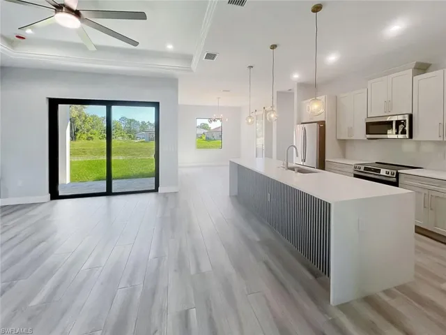 Kitchen featuring white cabinets, light wood-style floors, recessed lighting, stainless steel appliances, and pendant lighting