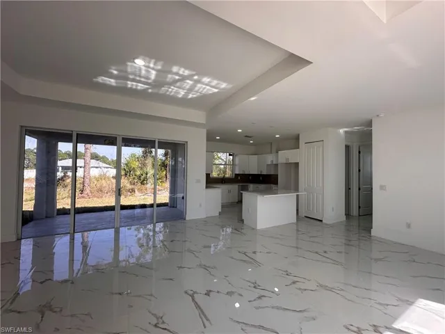 Unfurnished living room featuring a tray ceiling and sink