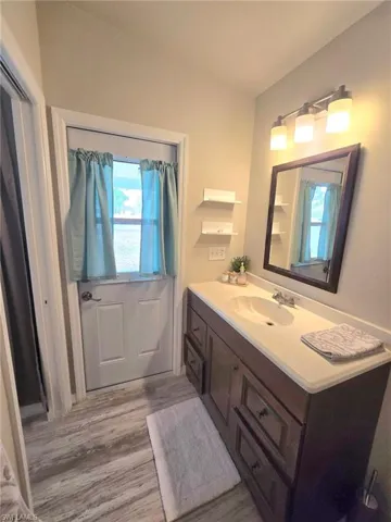 Bathroom featuring wood finished floors and vanity "pool door" to back screened patio.