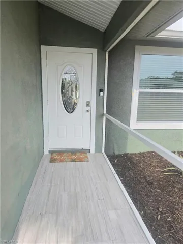 View of exterior entry featuring stucco siding and ceramic tile entry key pad and ring doorbell