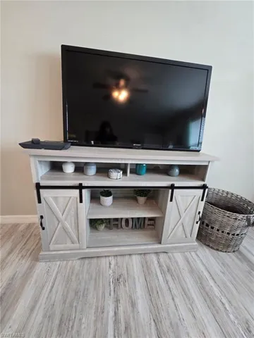 Detailed view of tv cabinet and television  wood finished floors and baseboards