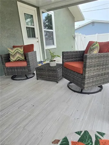 Wood like tile with outdoor lounge; bathroom door; outside concrete pad for gilling area