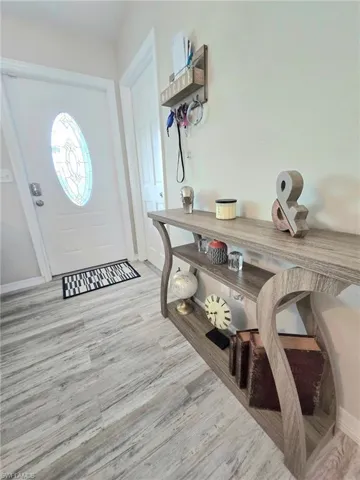Entrance foyer featuring wood finished floors and baseboards and welcoming table including decor