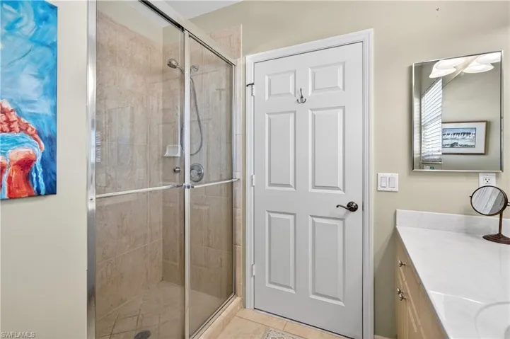 Bathroom with vanity, a stall shower, and light tile patterned floors