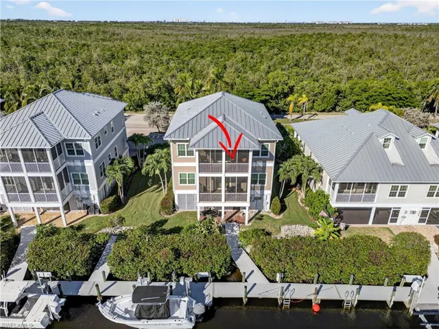 View of subject property featuring dock and lush mangroves