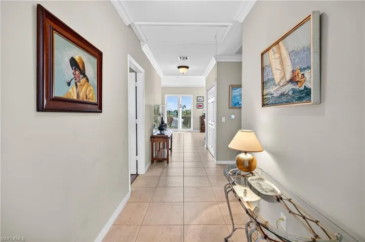 Foer featuring attic access, light tile patterned flooring, and ornamental molding