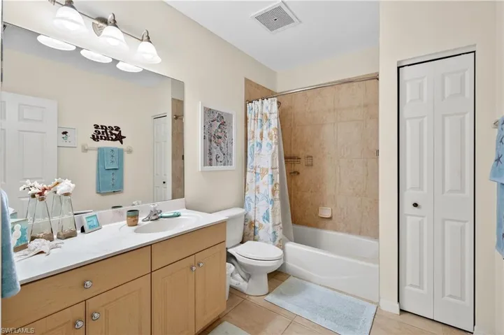 Bathroom featuring a  shower / bath combo, vanity, and light tile patterned floors