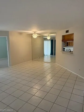 Unfurnished room featuring light tile patterned flooring and a ceiling fan