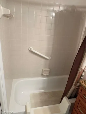 Bathroom featuring shower / bathtub combination with curtain and vanity