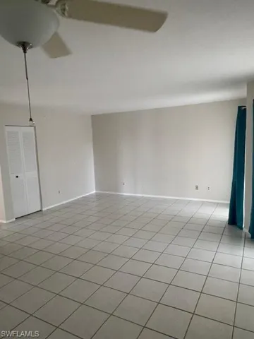 Unfurnished room with light tile patterned flooring and baseboards