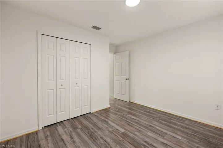 Unfurnished bedroom featuring wood-type flooring and a closet
