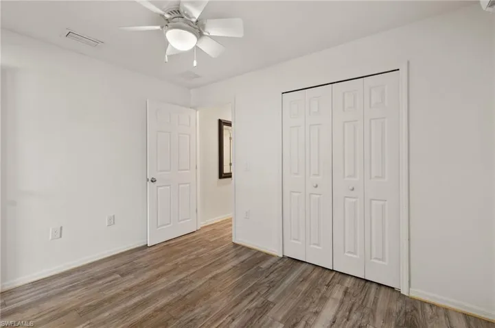 Unfurnished bedroom featuring ceiling fan, a closet, and wood-type flooring