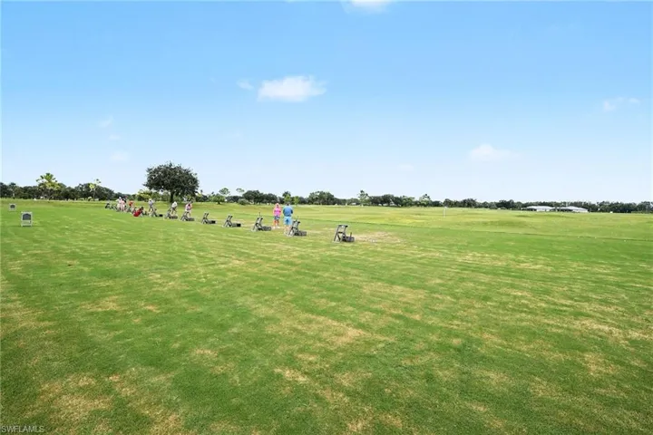 Expansive open-field grounds featuring a manicured lawn and designated golf practice stations