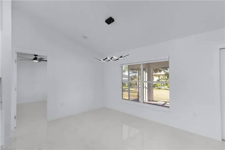 Empty room with ceiling fan and lofted ceiling