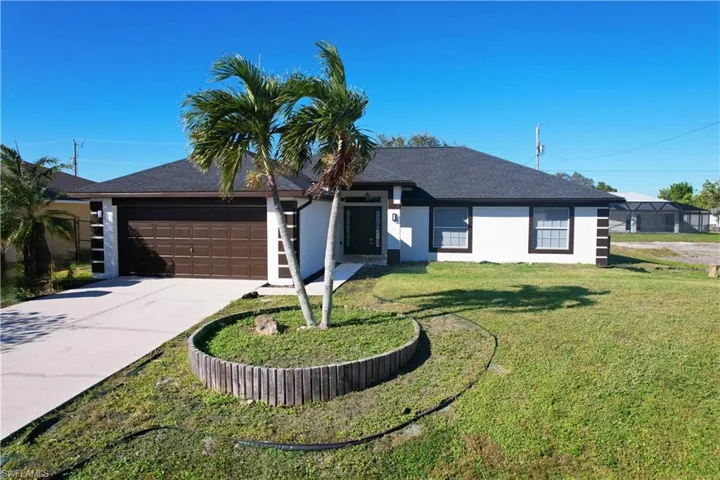 Single story home with a front yard and a garage