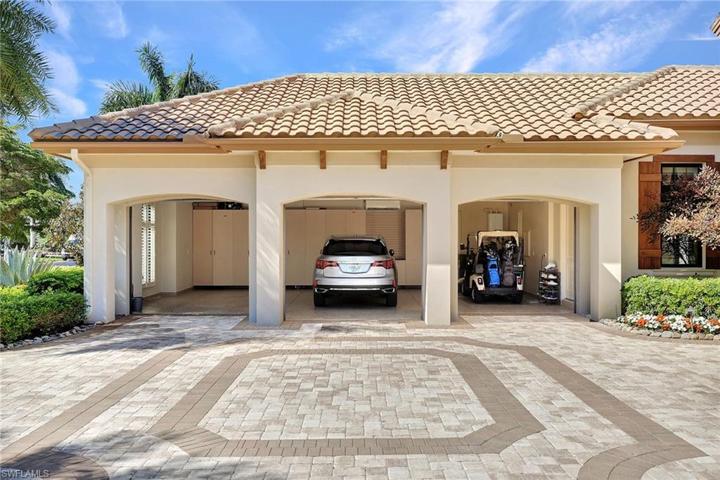 Air conditioned 3 car garage boasts a wall of custom storage and immaculate epoxy floor