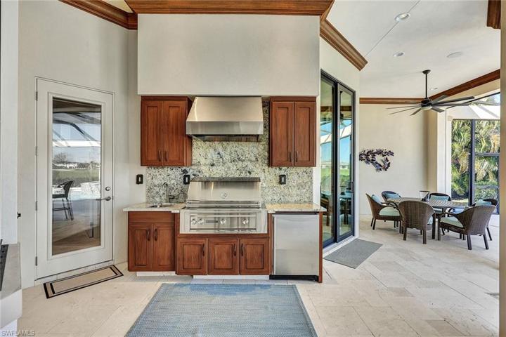 Outdoor kitchen features a Sedona gas rotisserie grill, refrigerator and sink