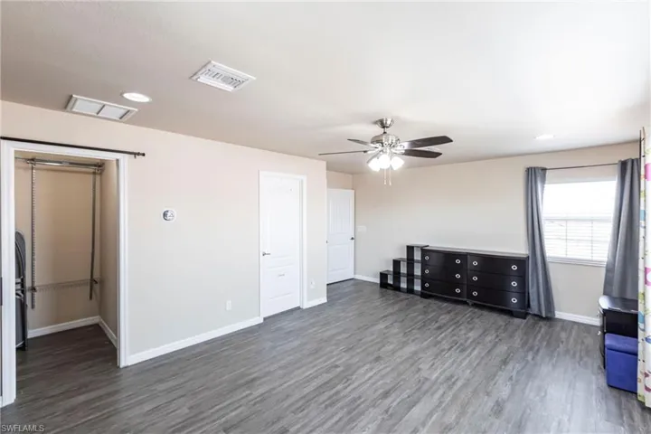 Unfurnished room with baseboards, wood finished floors, and visible vents
