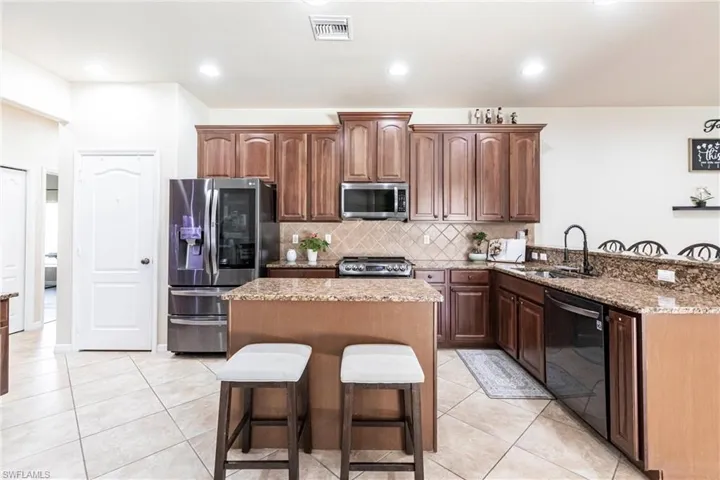 Kitchen with visible vents, a sink, a kitchen breakfast bar, and stainless steel appliances