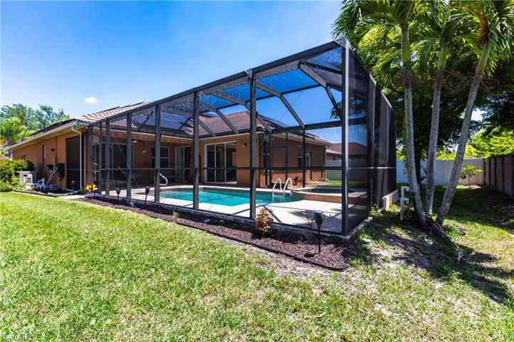 View of pool featuring a hot tub, fence, a fenced in pool, a yard, and a patio