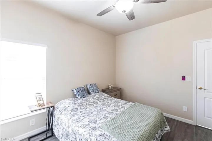 Bedroom with a ceiling fan, baseboards, and wood finished floors