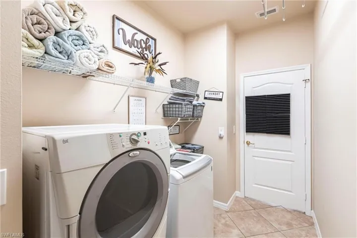 Clothes washing area with laundry area, visible vents, baseboards, independent washer and dryer, and light tile patterned floors