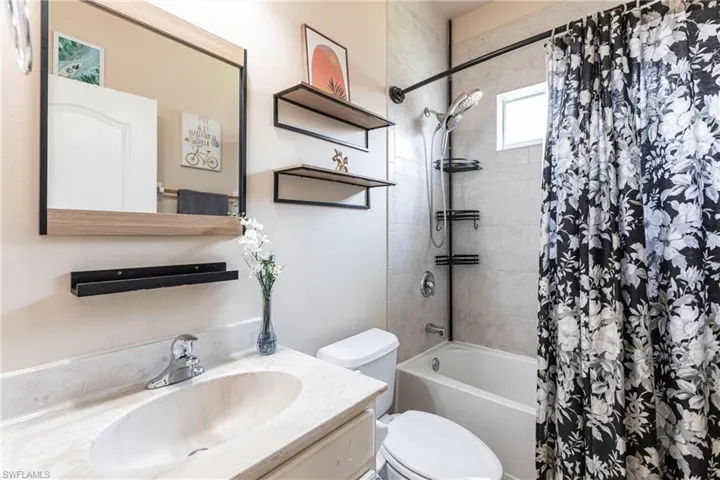 Bathroom with vanity, toilet, and shower / tub combo