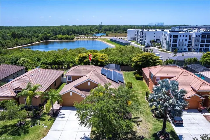 Aerial view featuring a water view and a view of trees