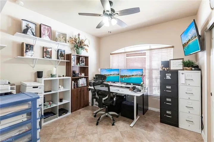Home office with light tile patterned floors and ceiling fan