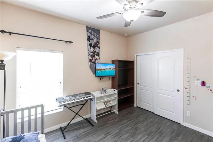 Office area featuring baseboards, a ceiling fan, and dark wood-style flooring