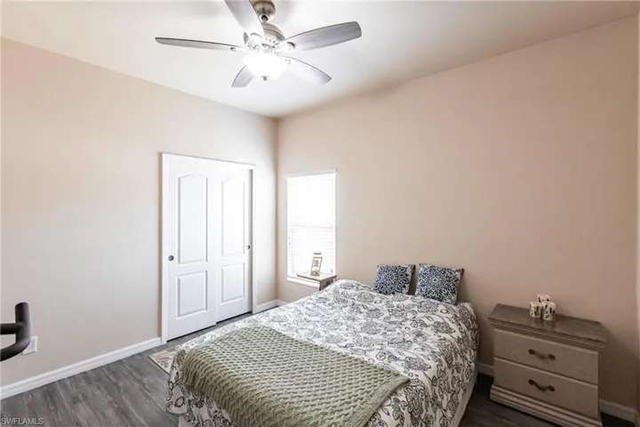 Bedroom featuring a ceiling fan, baseboards, and dark wood finished floors