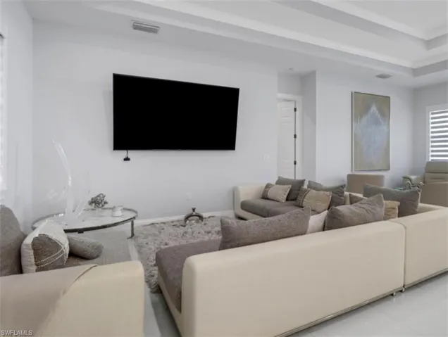 Living room featuring a tray ceiling and ornamental molding