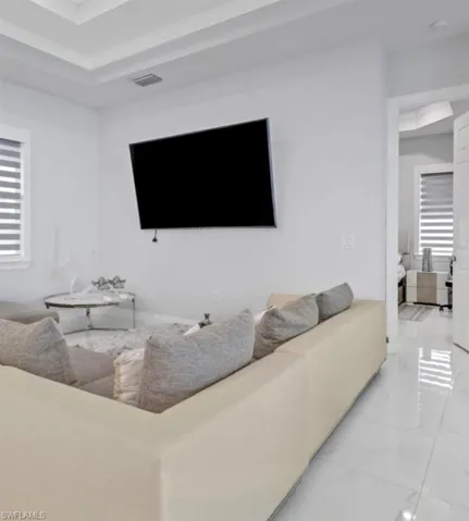 Living area with a tray ceiling and crown molding
