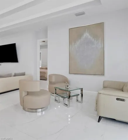Living area featuring marble finish floors and baseboards