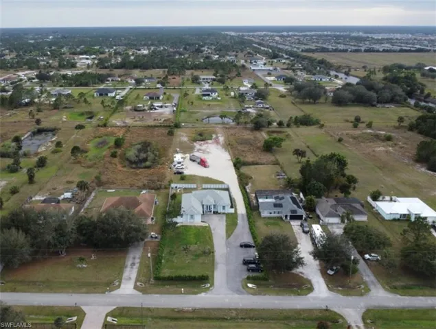 Aerial view of property and surrounding area with nearby suburban area
