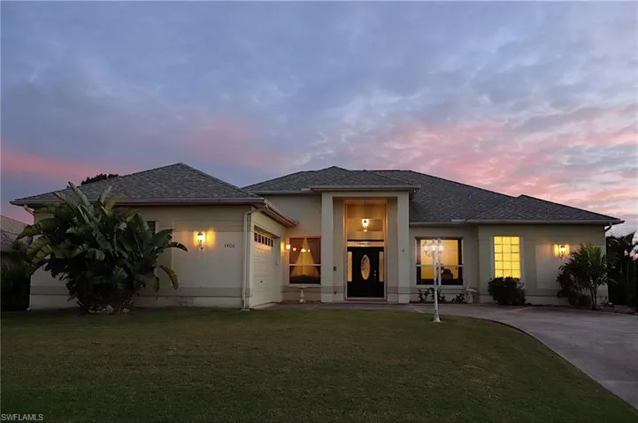 View of front of house with an attached garage, a front yard, roof with shingles, and driveway