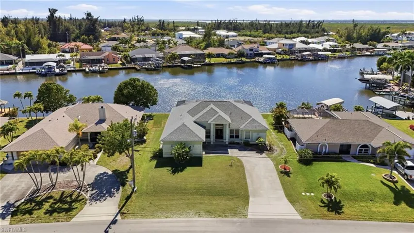 Aerial perspective of suburban area featuring a nearby body of water
