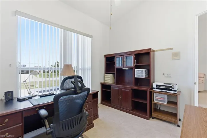 Office with light tile patterned floors, a ceiling fan, and lofted ceiling