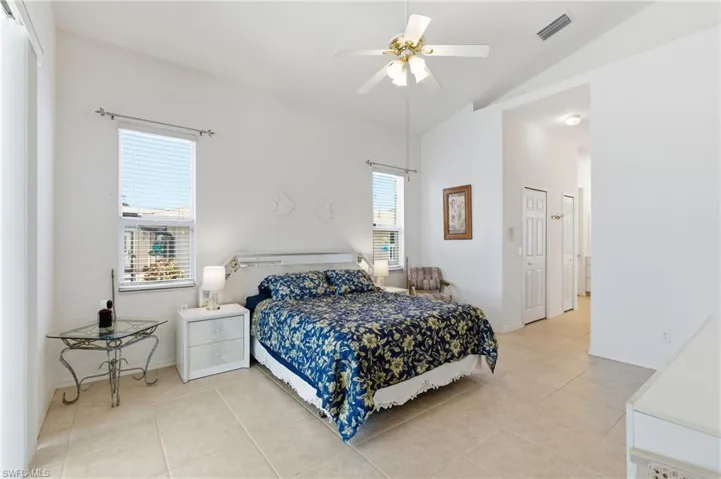 Bedroom featuring a closet, ceiling fan, lofted ceiling, and light tile patterned flooring