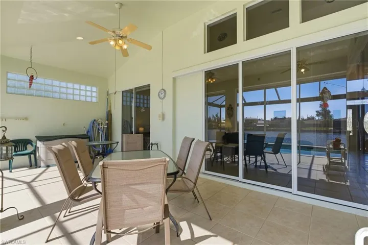 View of patio featuring outdoor dining area, ceiling fan, and a water view