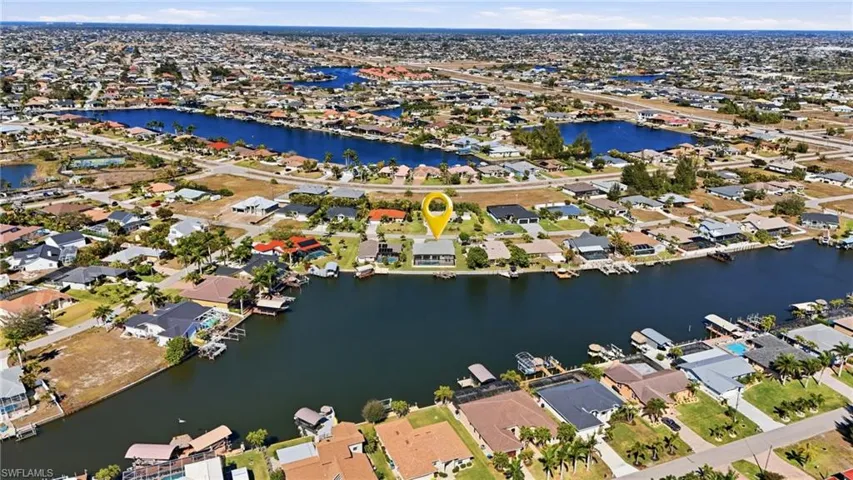 Aerial view of property and surrounding area featuring nearby suburban area