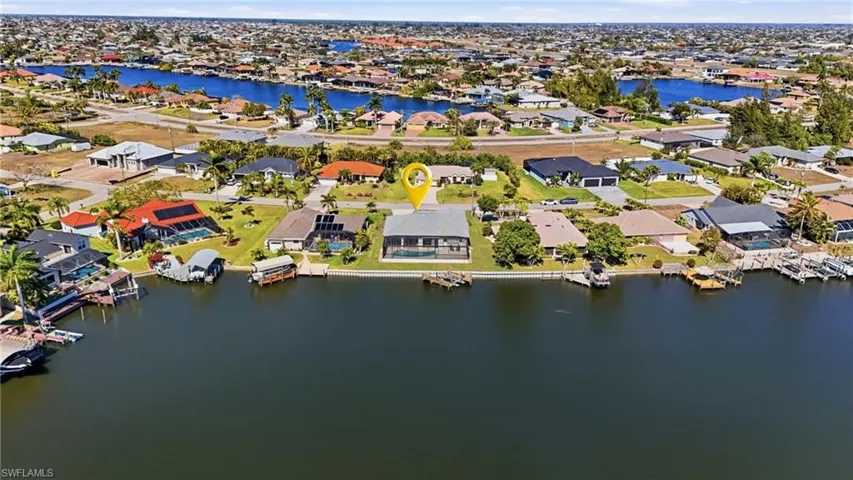 Aerial view of property's location with a large body of water and nearby suburban area