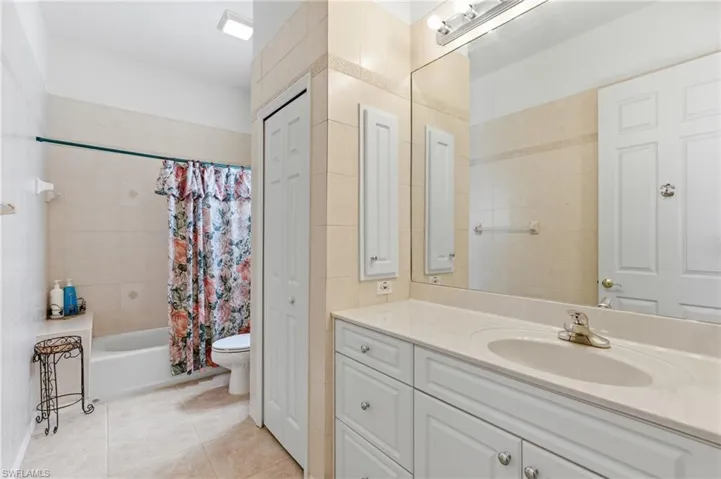 Full bathroom featuring a closet, vanity, shower / tub combo, and light tile patterned flooring