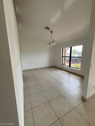 Spare room with light tile patterned floors and a textured wall