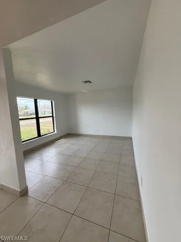 Spare room with baseboards and light tile patterned floors