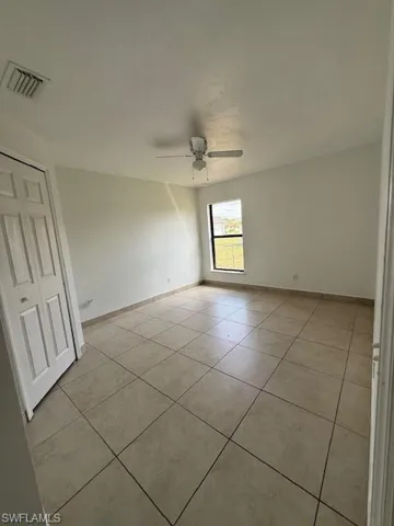 Spare room with light tile patterned flooring and a ceiling fan